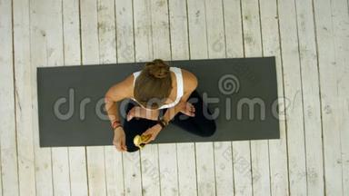 瑜伽课后吃香蕉的年轻女子